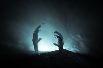 Halloween concept, zombie hand rising out from the ground or zombie hand coming out of his grave