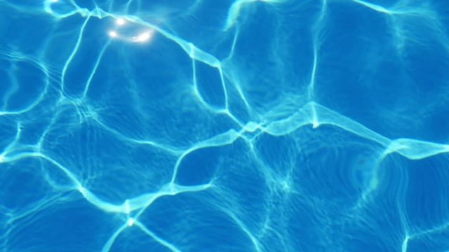 An amazing view of entertaining celeste waters in a swimming pool with shimmering net altering cheerfully in summer in slow motion