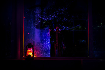 Horror Halloween concept. Burning old oil lamp in forest at night. Night scenery of a nightmare scene.