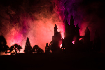 Mysterious medieval castle in a misty full moon. Abandoned gothic style old castle at night