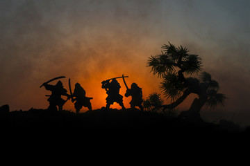 Silhouette of two samurais in duel. Picture with two samurais and sunset sky.