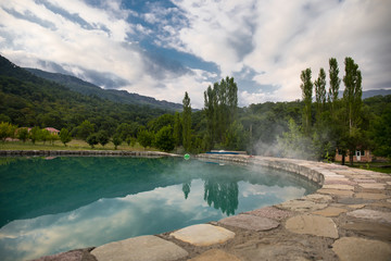 selective focus table near outdoor swimming pool with mountain background