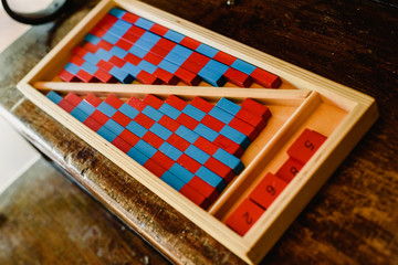 Game to learn to count, made of blue and red wood, inside a classroom montessori.