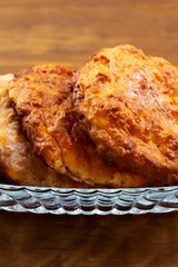 Beautiful round biscuits with a golden  crust in a glass plate, close-up, vertical frame.