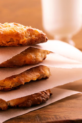 Round homemade cookies, arranged with sheets of paper on a wooden background, vertical frame.