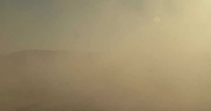 Motorcycle passing camera on dry lake bed.