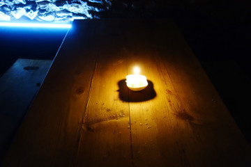 A fiery candle illuminating a wine cellar