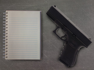notebook and gun on table  In school.