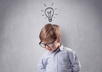 Smart little junior in front of a drawn up grey wall with childlike concept