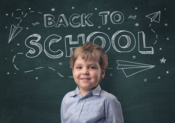 Adorable little boy with blackboard and back to school concept