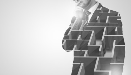 Young businessman in suit standing with maze graphic 