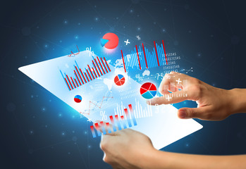 Young female hand holding a tablet with red and blue charts