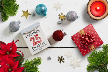 weihnachtliche Dekoration und Abreißkalender mit dem 25.12.2018 auf weißem Holzuntergrund