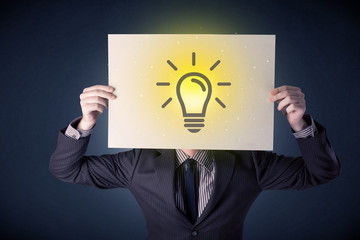 Young businessman hiding behind a lightbulb drawn on paper