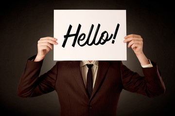 Young businessman hiding behind a greeting drawn on paper