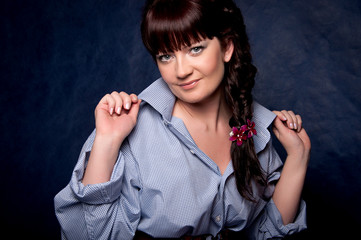 Beautiful brunette in a man's shirt posing in the studio.