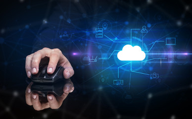 Hand using wireless mouse in a dark environment with cloud technology and online storage concept