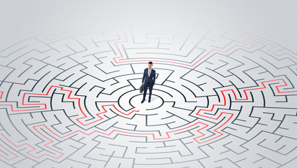 Young entrepreneur standing in a middle of a labyrinth with the solution
