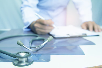 doctoc writing computer medical working information with stethoscope on desk.