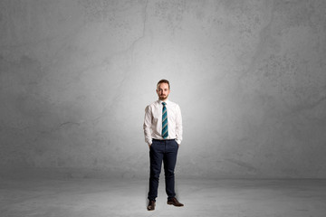 Alone handsome businessman standing in a dark empty room