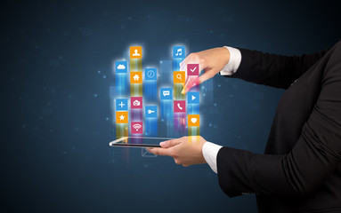 Female elegant hand holding tablet with colourful application icons