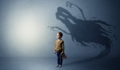 Scary ghost shadow in a dark empty room with a cute blond child
