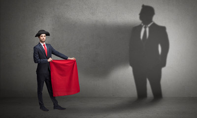 Businessman standing with red cloth on his hand and his shadow on the background
