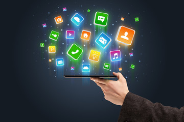 Businessman hand using phone with flying application icons around
