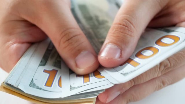 Closeup 4k footage of male finger counting 100 US dollar banknotes