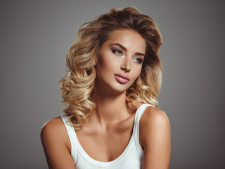 Obraz premium Photo of a beautiful young blond girl with curly hair