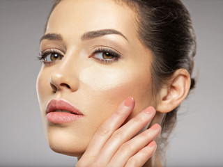 Cosmetic makeup tonal foundation is on woman's face.
