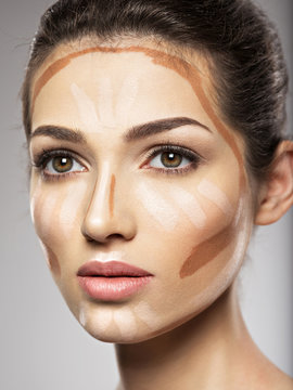 Cosmetic makeup tonal foundation is on woman's face.