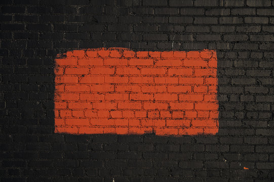 Red rectangle painted on black brick wall