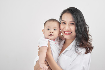 Happy loving family. Young smiling mother hugging laughing baby.