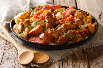 Ojahuri fried meat with potatoes, tomatoes, onions, herbs and spices close-up. horizontal