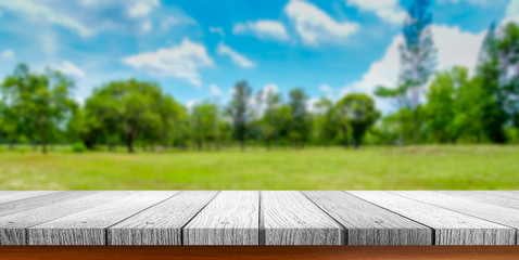 Fototapeta premium Wooden tabletop with green park nature blurred background