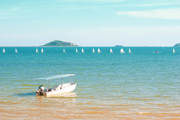 Small motor boat in blue sea with sailing on background