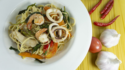 Spaghetti seafood in a white dish on pasta line pattern, Top view with copy space for your text..