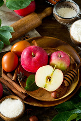 Autumn cooking background. Apple baking concept. Fresh red apples and ingredients for baking on a wooden table.
