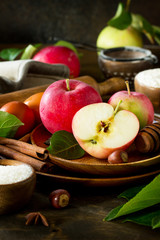 Apple baking concept. Fresh red apples and ingredients for baking on a wooden table. Copy space.
