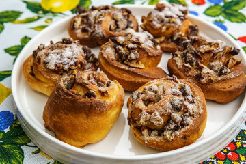 freshly baked buns with nuts on colored towel top view.