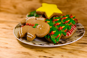 Plate with different christmas gingerbread cookies on wooden table