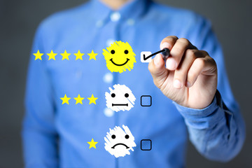 Businessman hand putting check mark a checkbox on happy face icon and five star rating. Customer...