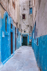 Fototapeta na wymiar A small street in the medina of Essaouira in Morocco. The bottom of the walls is painted in blue