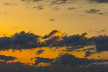 The clouds in the sky are colored by the sun at dawn.