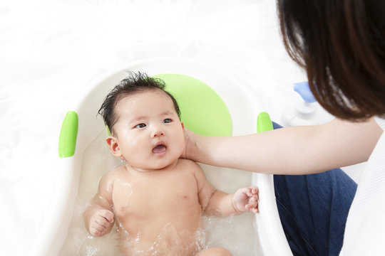 新生児の入浴・沐浴方法を説明するマニュアル用写真、沐浴時の新生児の安心・安定する支え方イメージ