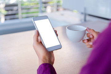 Mockup image of man's hands holding white mobile phone with blank screen technology and lifestyle concept.