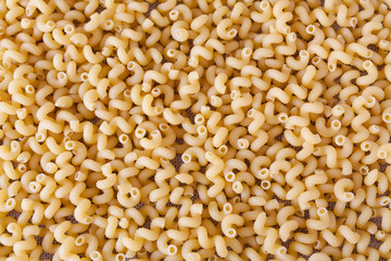 Pasta in form of spirals on a rough canvas