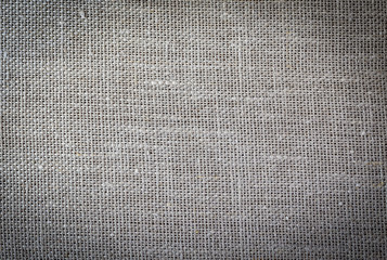 Texture of rough linen fabric. Toned. With a dark vignette.