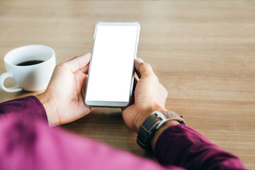 Mockup image of man's hands holding white mobile phone with blank screen technology and lifestyle concept.